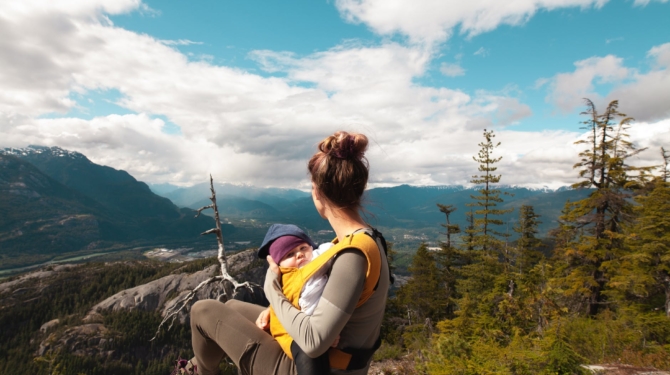 mother carrying her baby while looking at the nature scenery